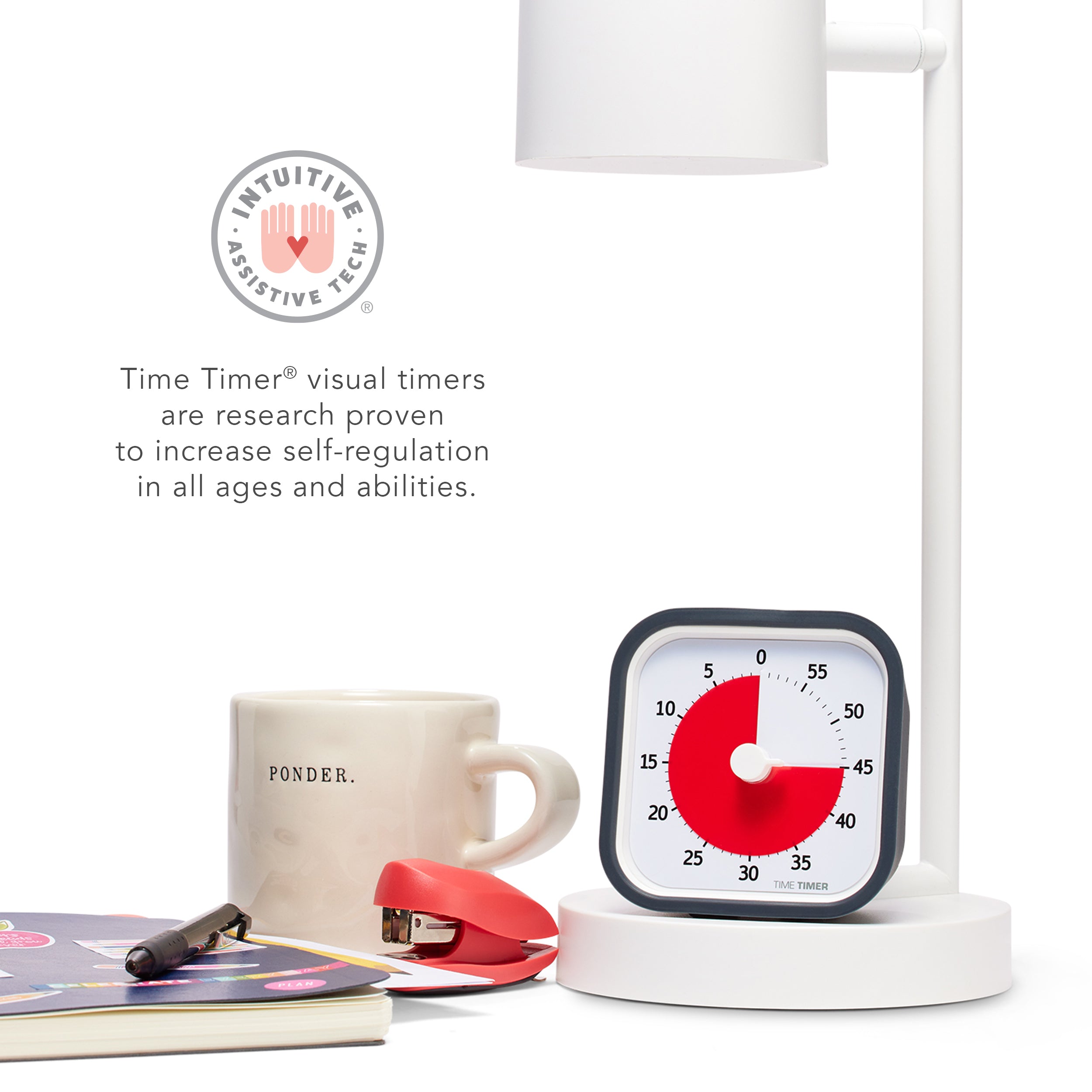 The Time Timer MOD 60 Minute Visual Timer is shown sitting under a desk lamp next to other office and teacher supplies. There is a icon that states "Intuitive Assistive Tech" and it reads "Time Timer visual timers are research proven to increase self-regulation in all ages and abilities."