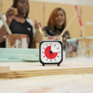 Timer on a table with blurred people in the background