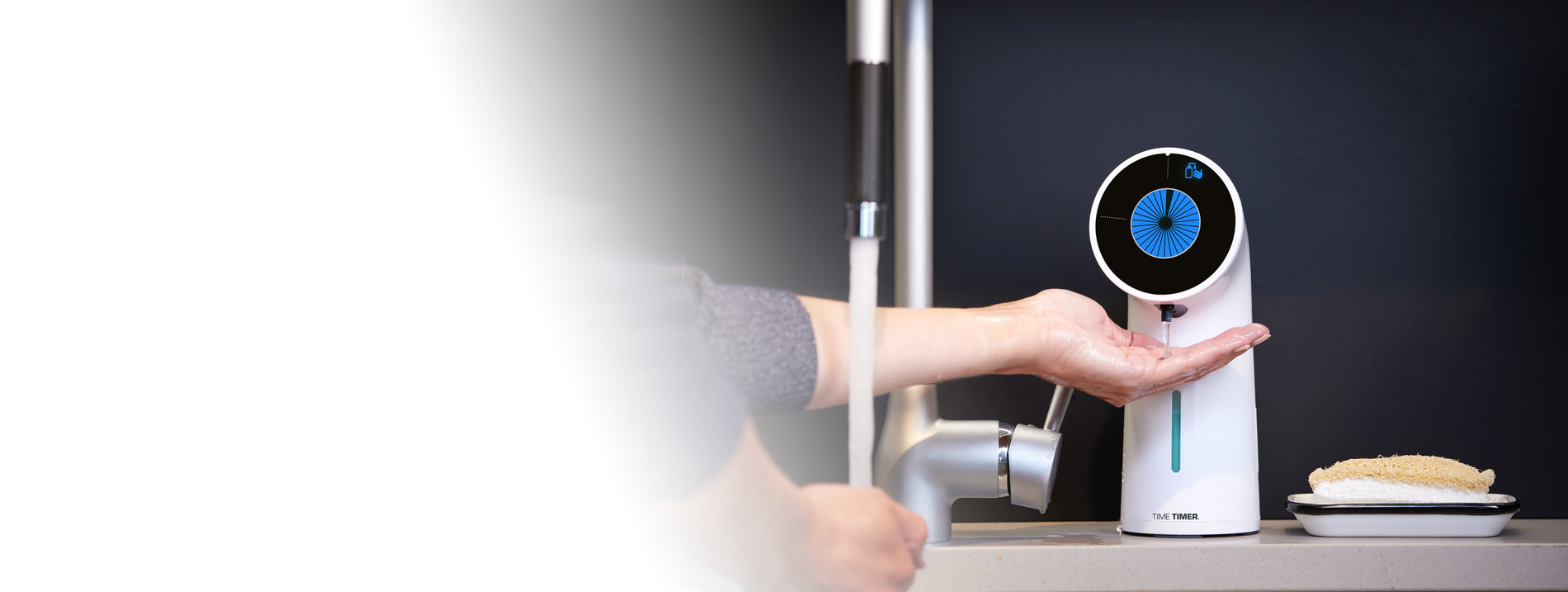 Person using a handheld electronic device with a digital display on a kitchen counter.