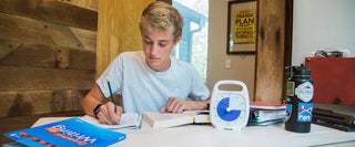 A young teen boy using Time Timer to study and do homework.