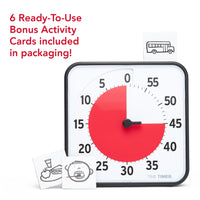 Included in the packaging of the Time Timer Original 12" are 6 cut-out Bonus Activity Cards. This image shows the 60-minute visual timer with the cut out of a bus on top of the timer. Next to the timer are pictos that represent a lunch plate and a person brushing their teeth.  